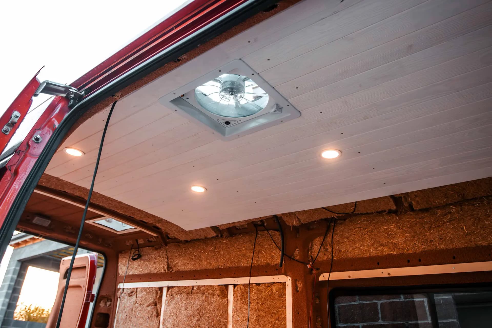 Fourgon en travaux avec le lambris au plafond et la paille de riz sur les côtés